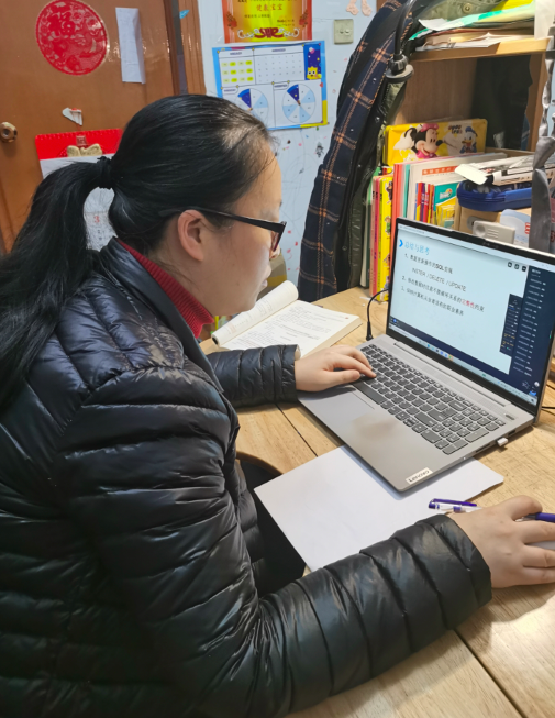 喻佳在回看授课视频,记录学生上课情况。